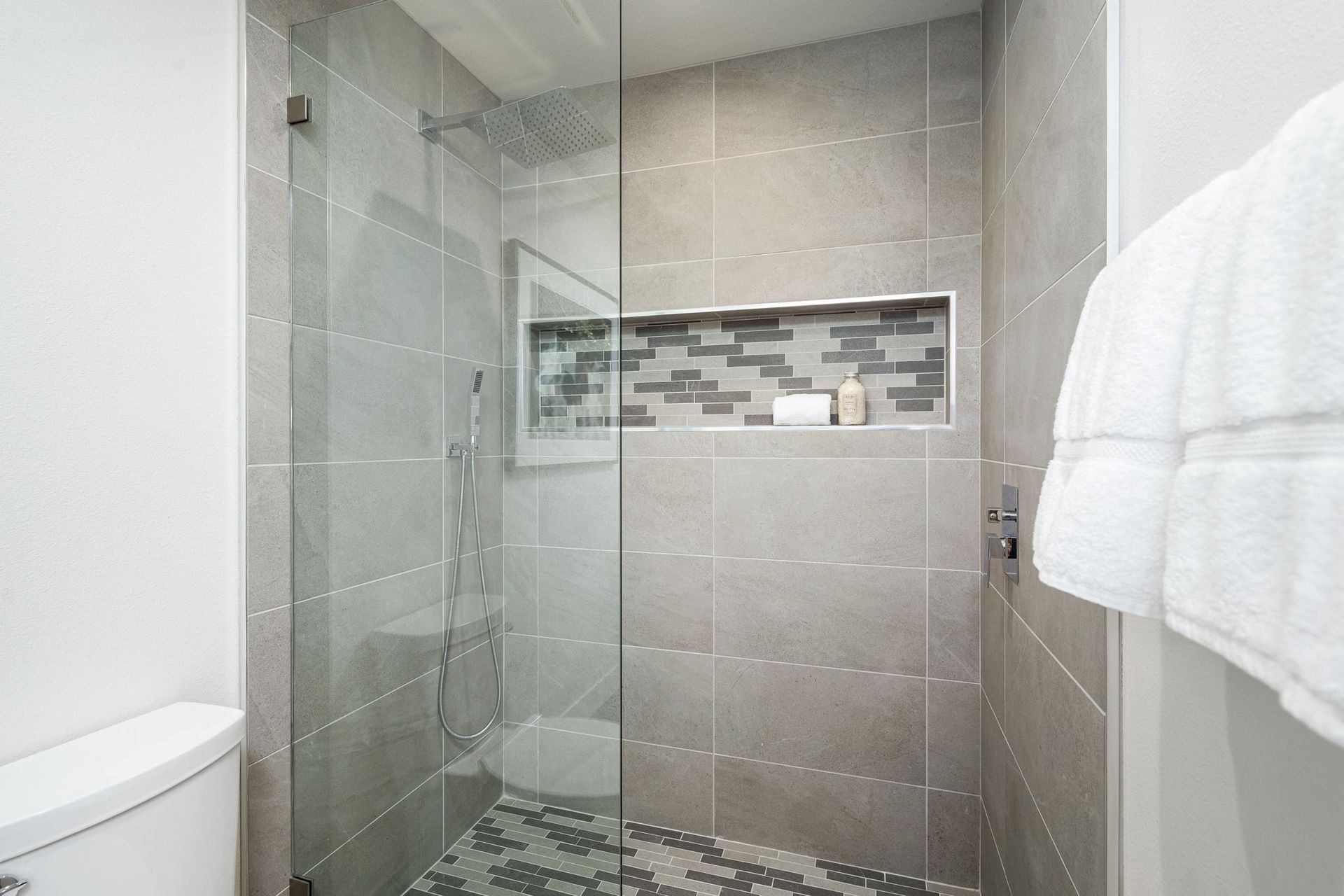 A bathroom with a walk in shower and a toilet.