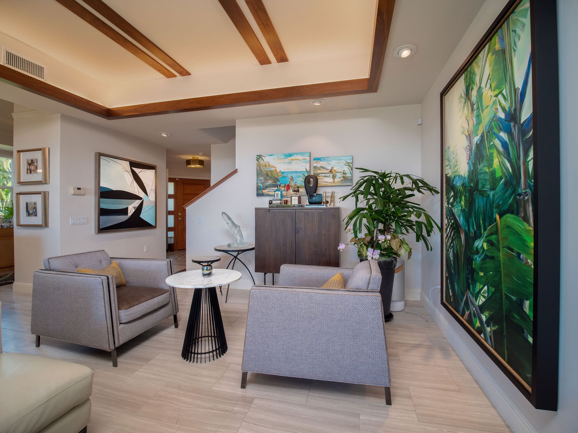 Living room with modern furniture, art, and a large green painting. Beige and brown accents.
