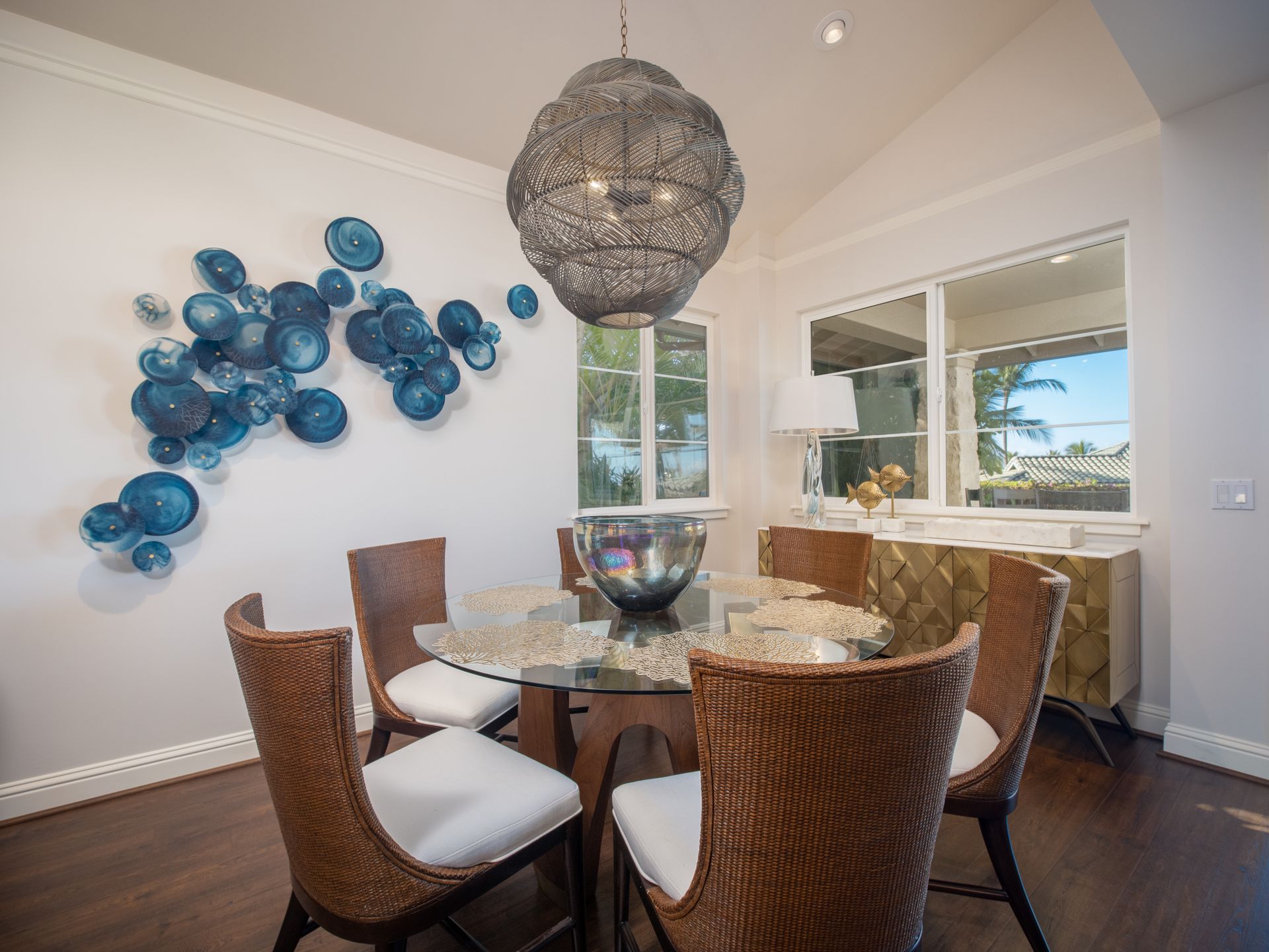 A dining room with a table and chairs and a chandelier hanging from the ceiling.