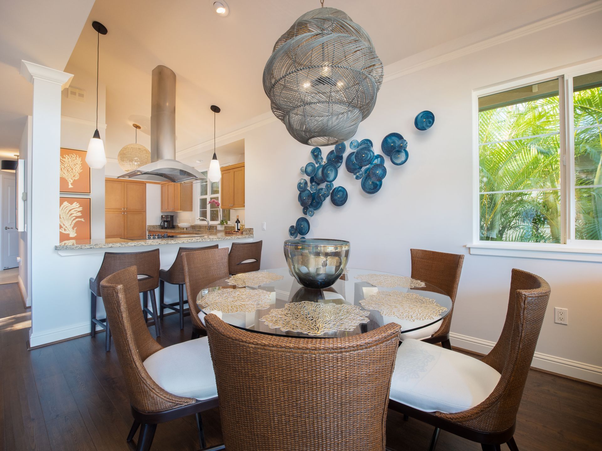 A dining room with a table and chairs and a chandelier hanging from the ceiling.