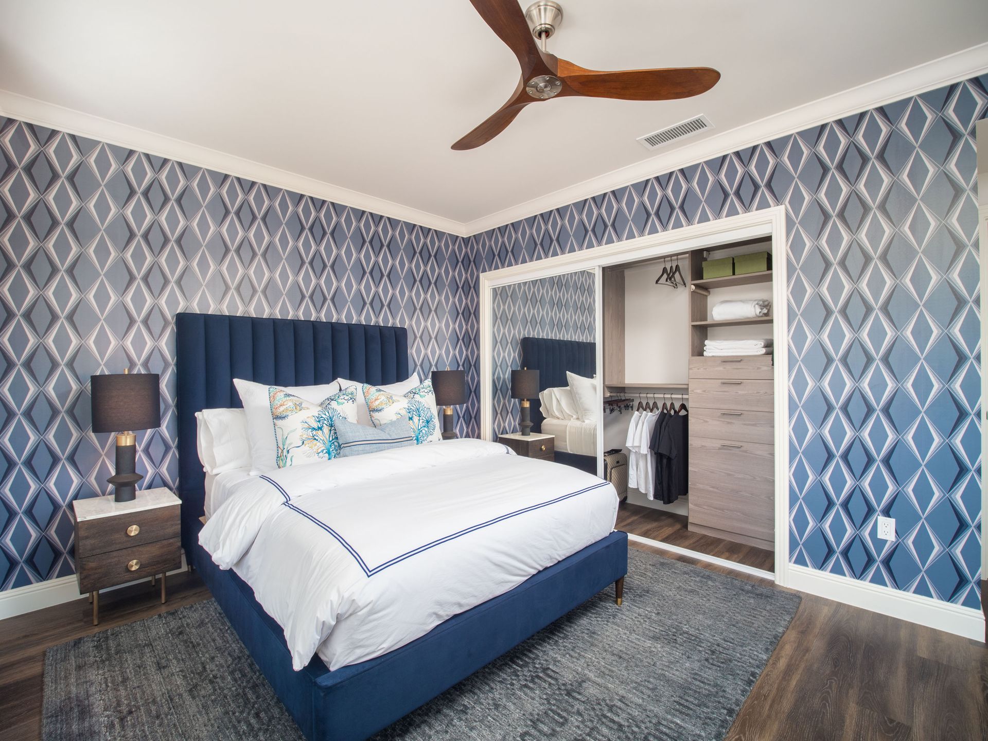 A bedroom with a large bed and a ceiling fan