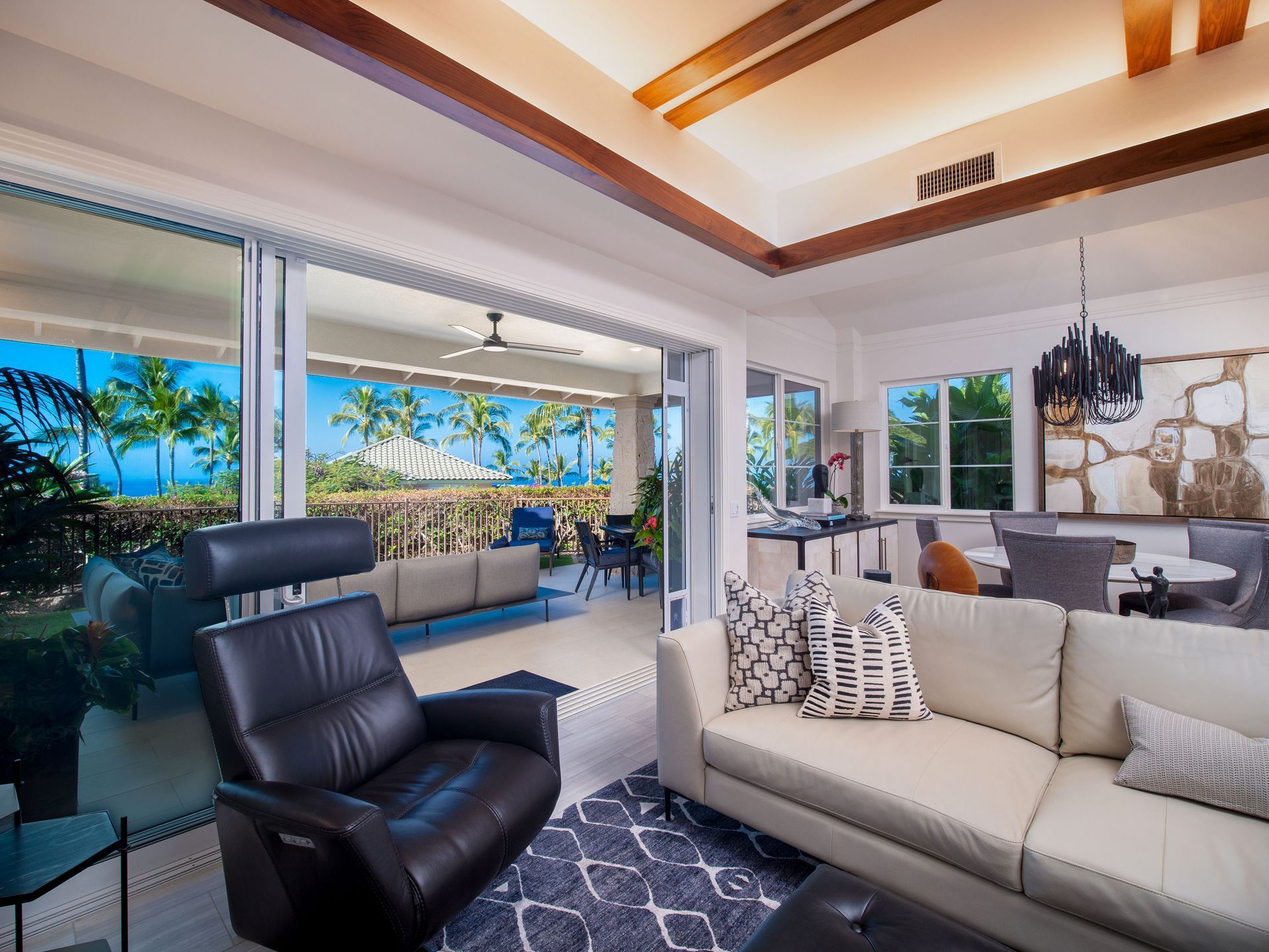 A living room with a couch and chair and a view of the ocean.