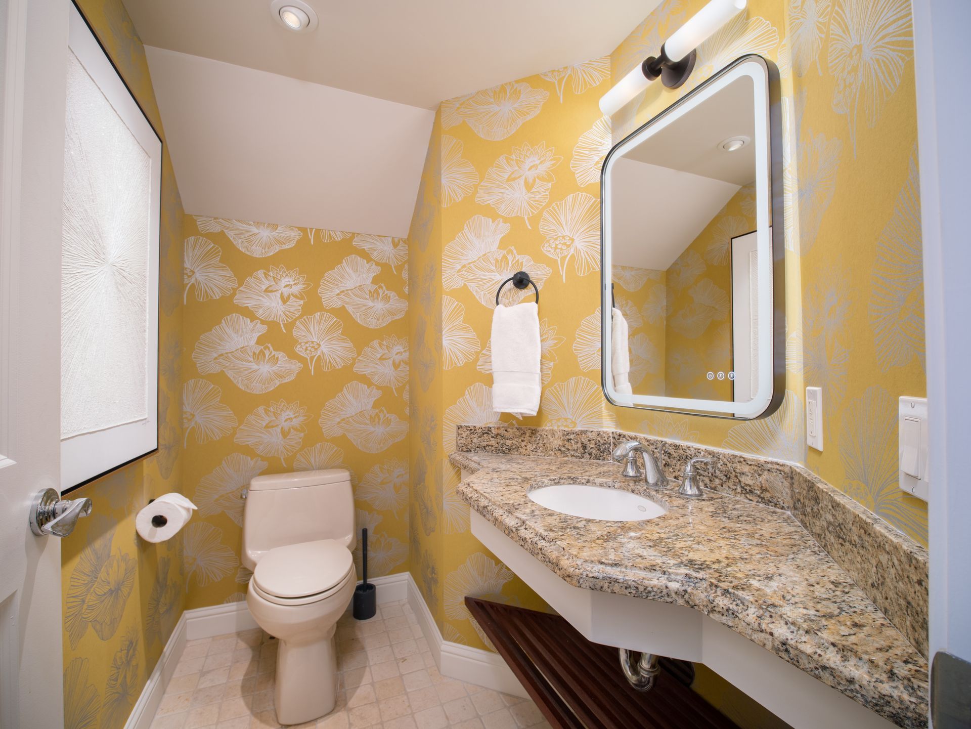 A bathroom with a toilet , sink and mirror