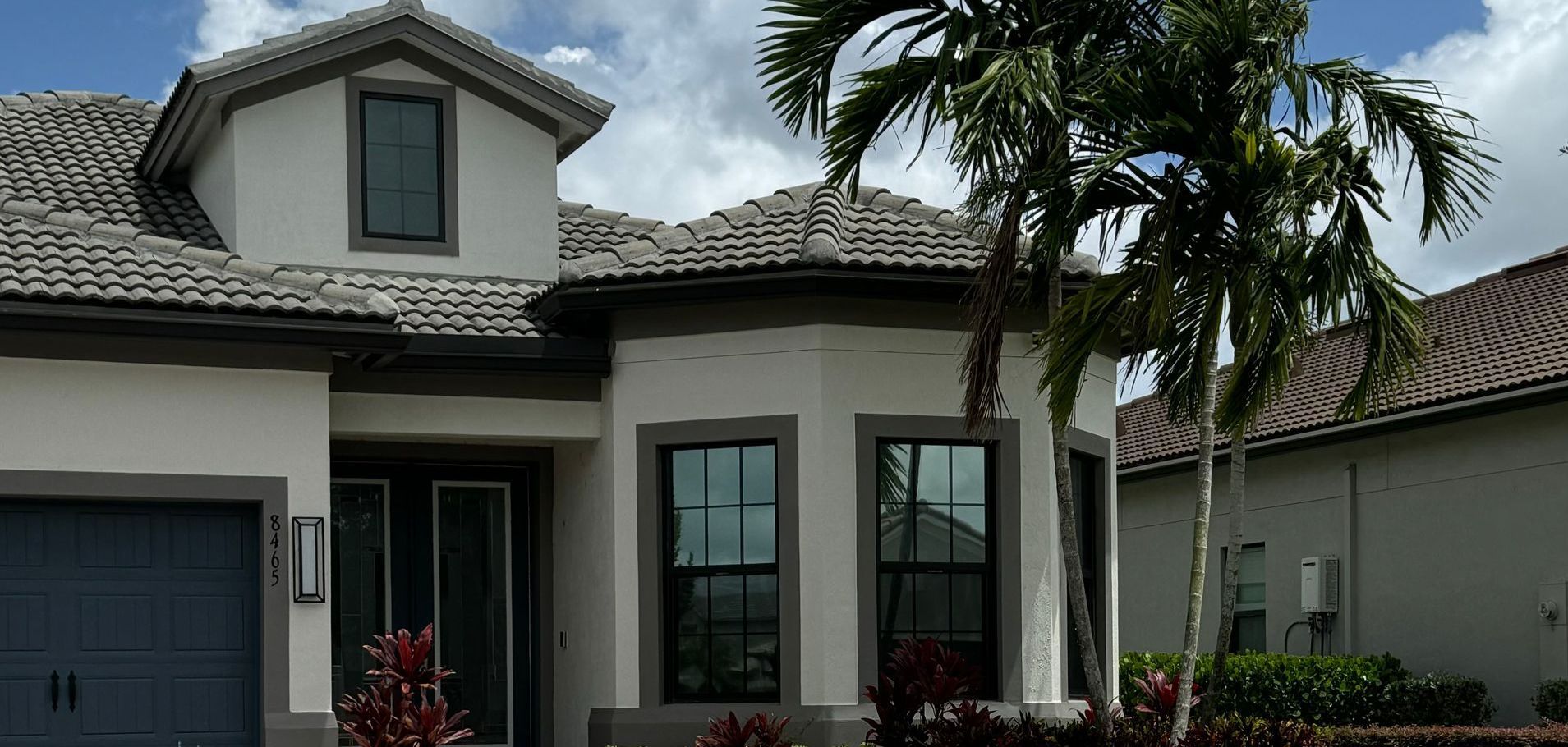 A white house with a palm tree in front of it