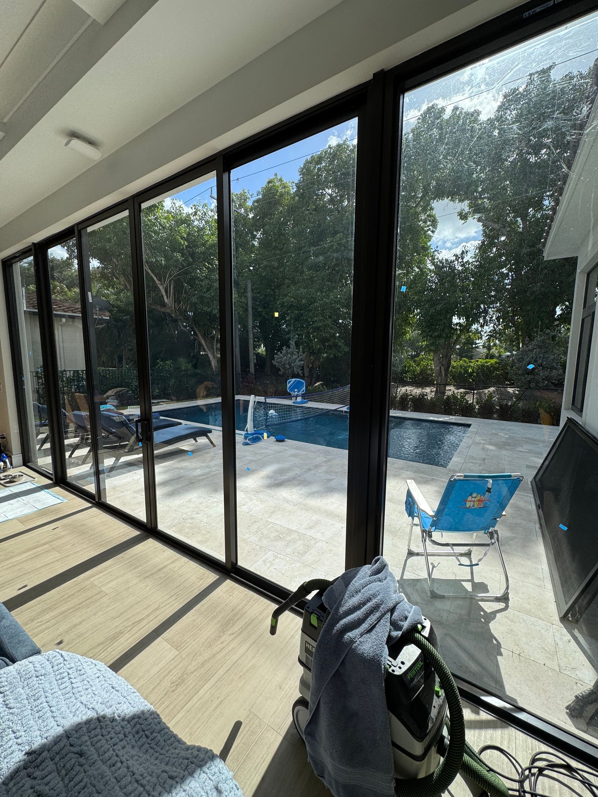 A room with a lot of windows and a pool in the background.