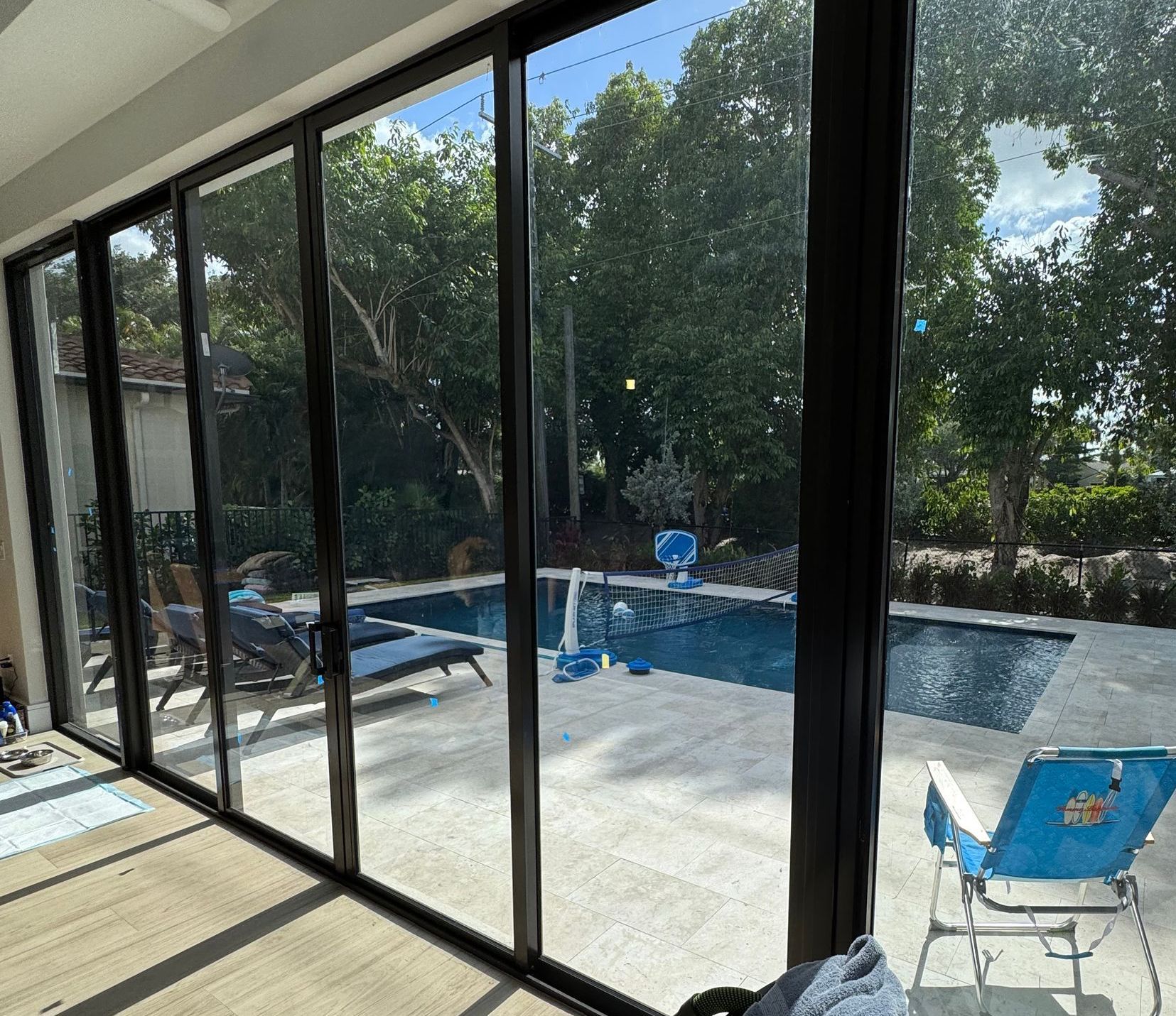 A view of a swimming pool through a sliding glass door.