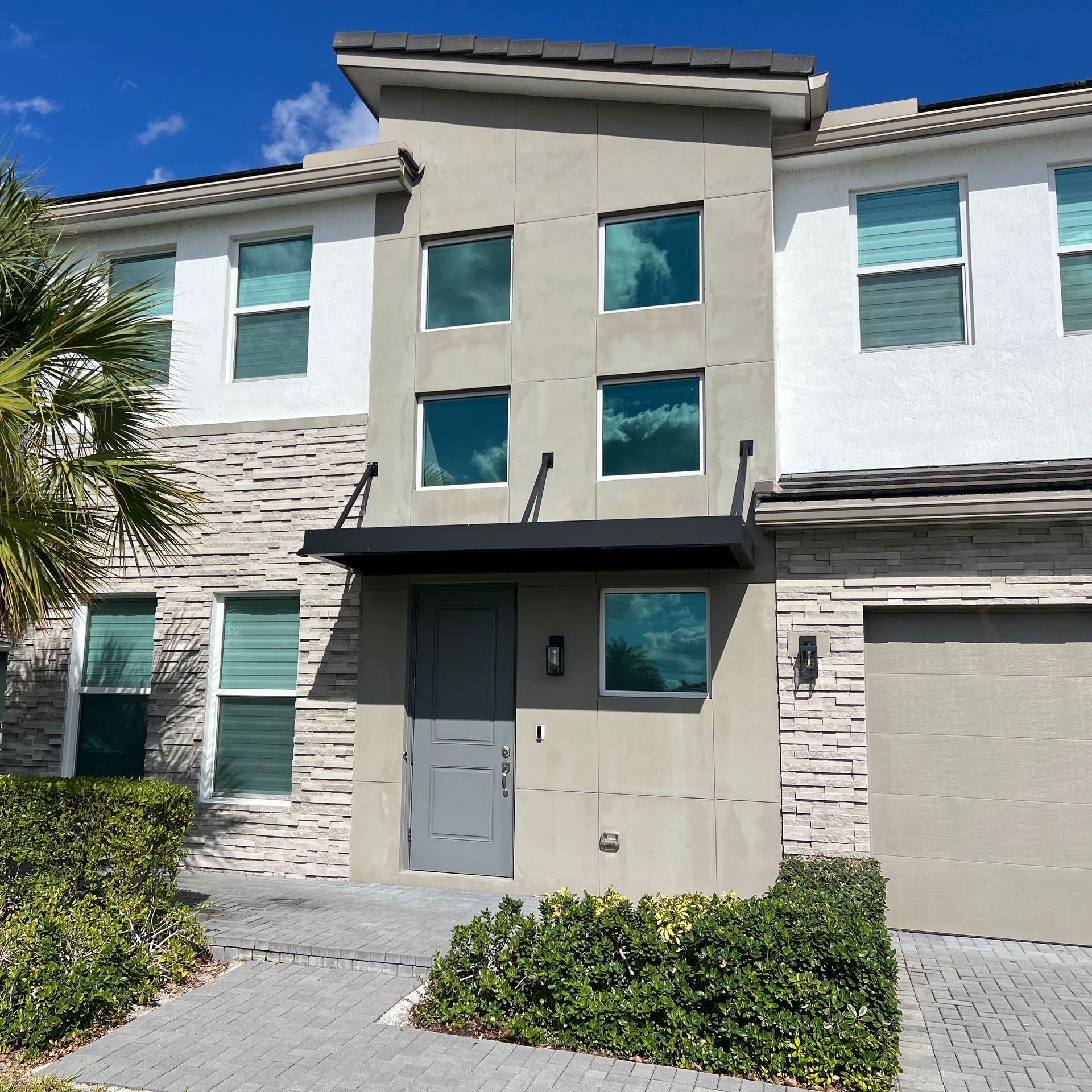 A house with a lot of windows and a canopy over the door
