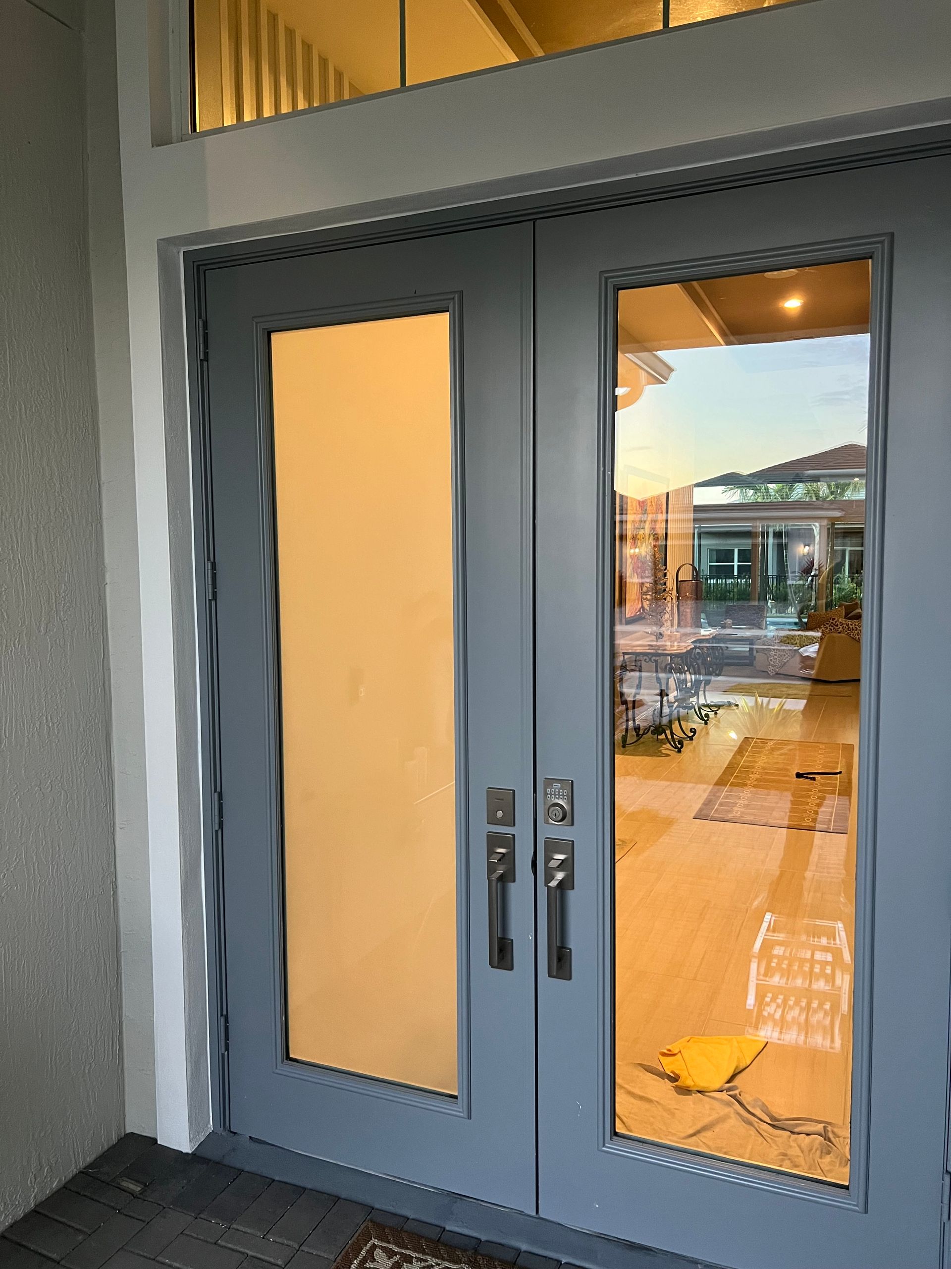 A close up of a door with a reflection of a house in it.