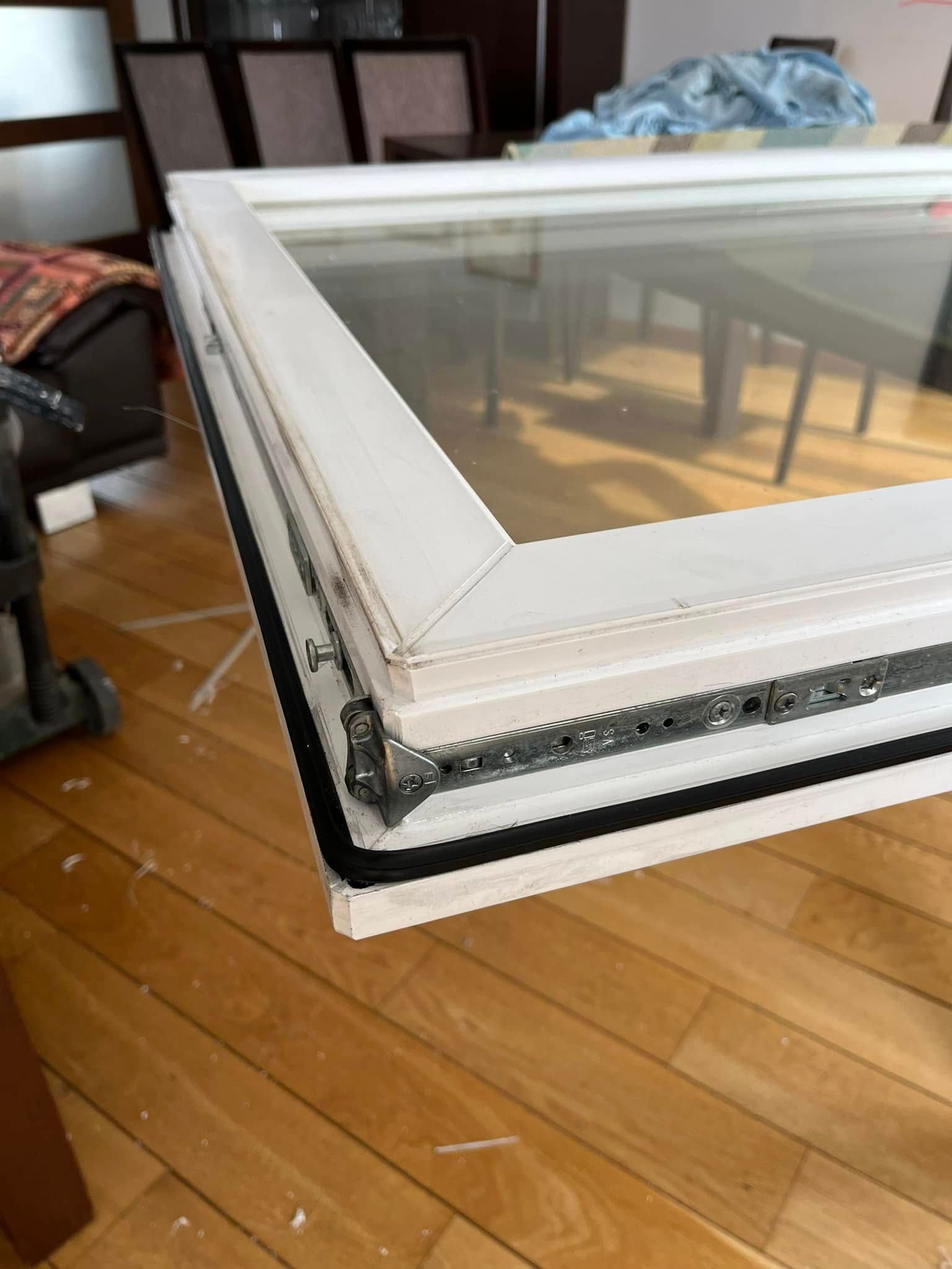 Baltas lango rėmas sėdi ant medinių grindų svetainėje.