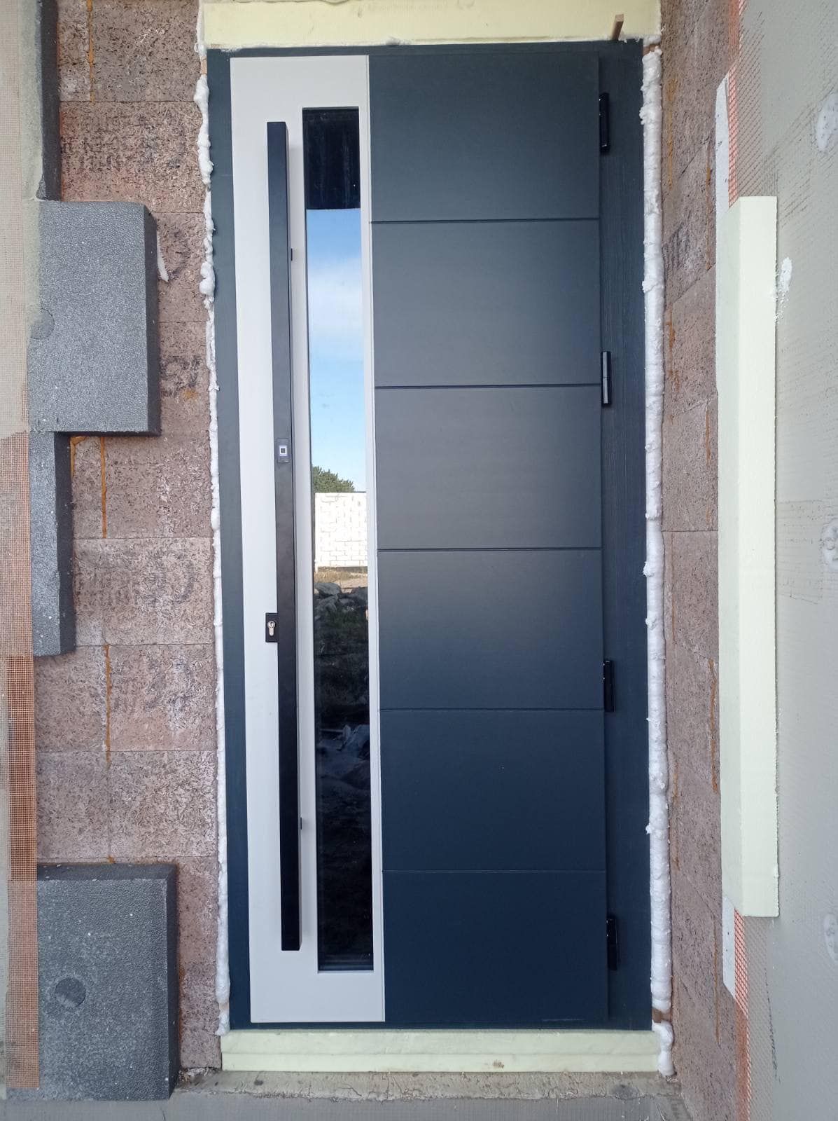 Juodai baltos durys su stikliniu langu.