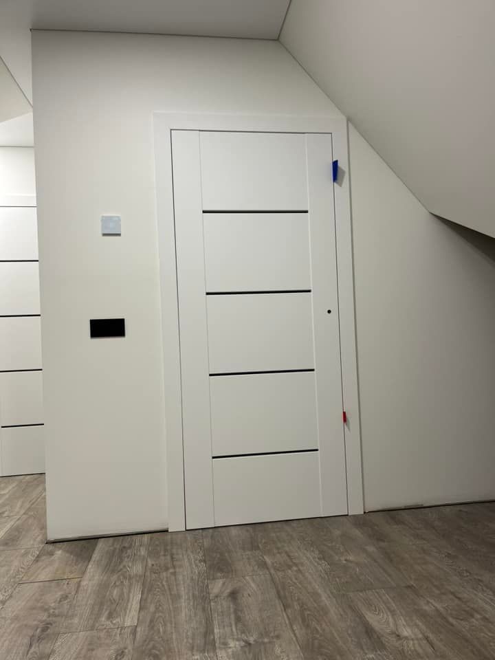 Baltos durys po laiptais kambaryje.