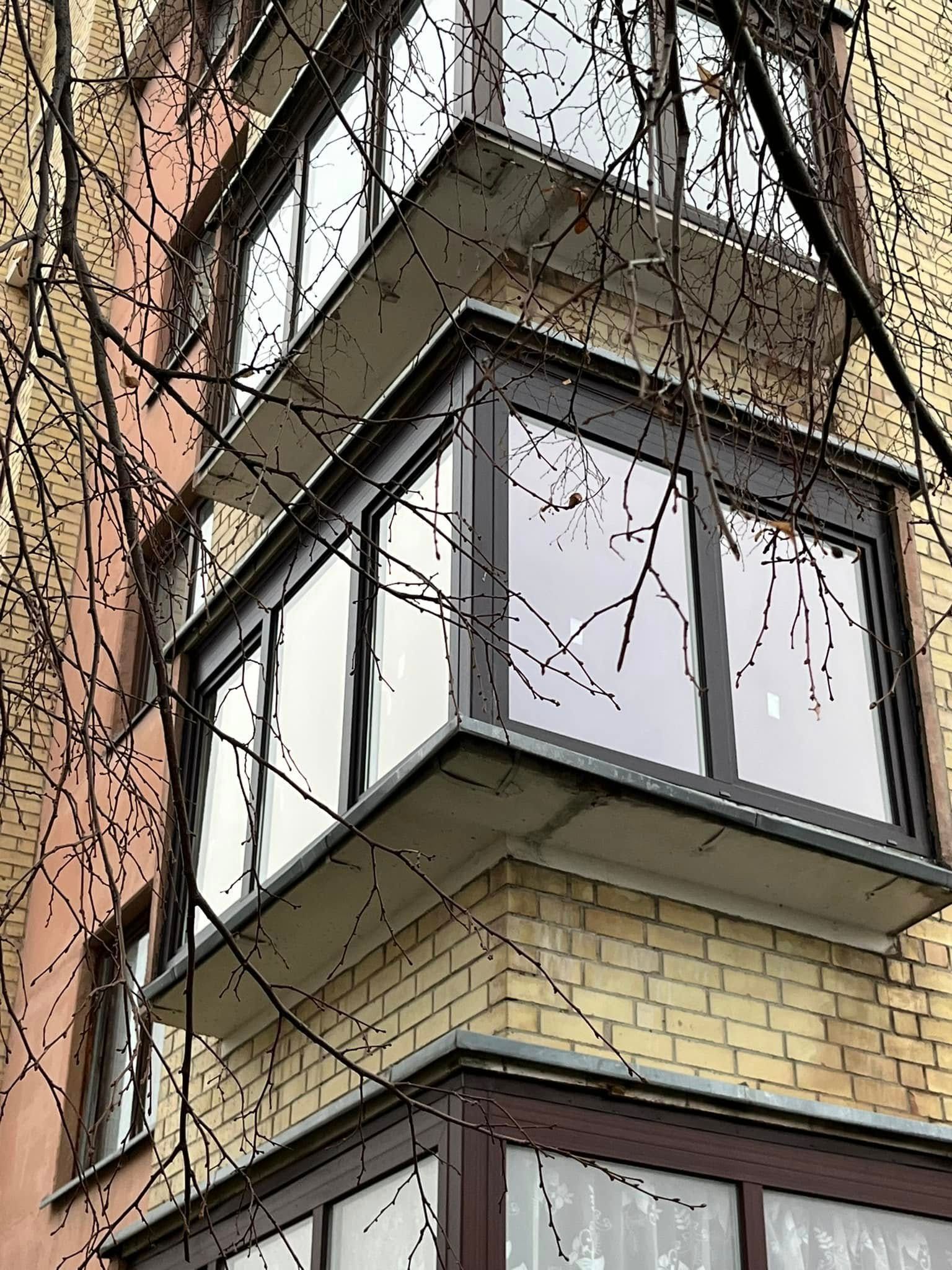 Mūrinis pastatas su balkonu jo kampe.