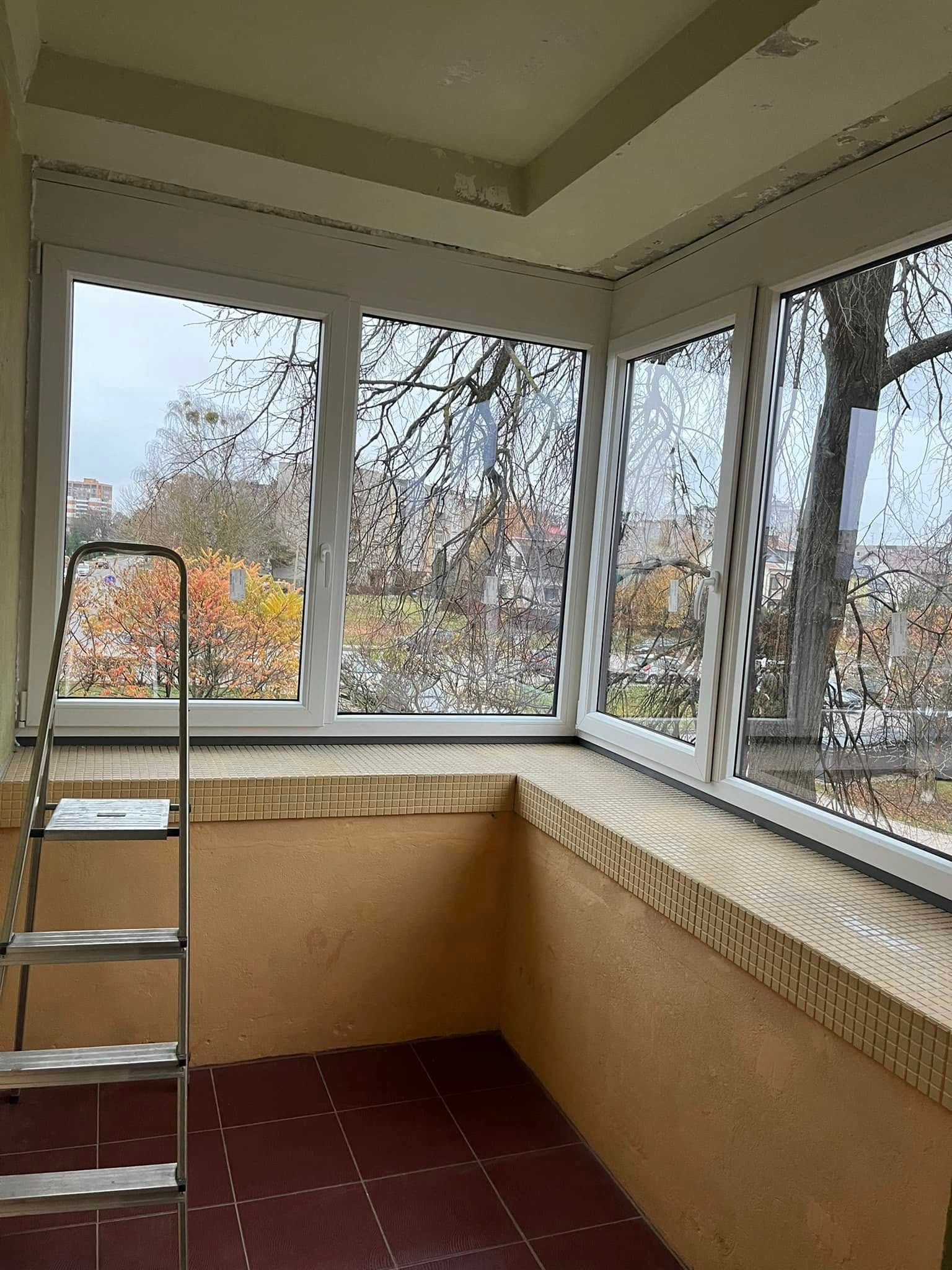 Kambaryje yra kopėčios su daug langų.