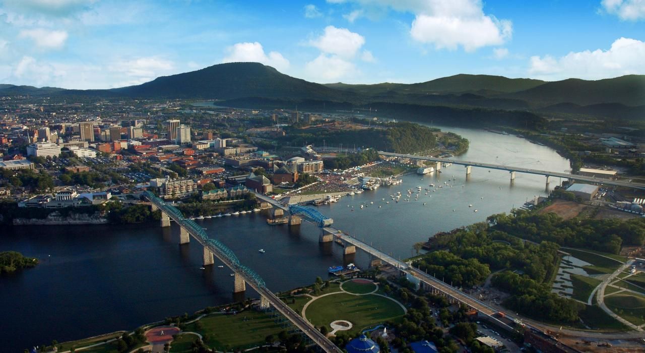 An aerial view of a city and a river with mountains in the background.