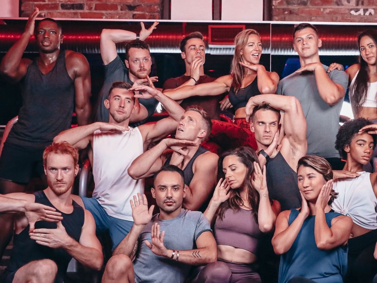 A group of people are posing for a picture in a gym.