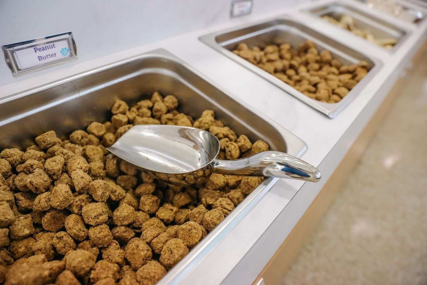 A tray of food with a scoop in it is on a counter.