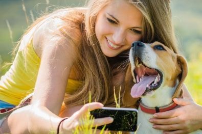 A woman is taking a selfie with her dog.