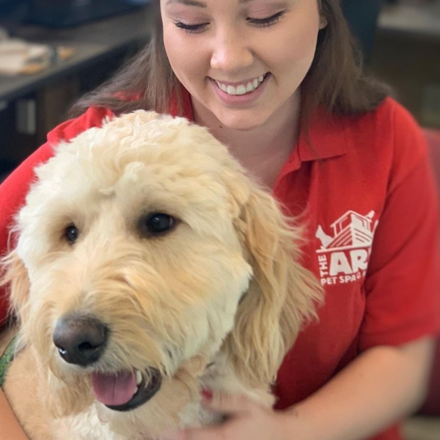 A woman in a red shirt is holding a dog