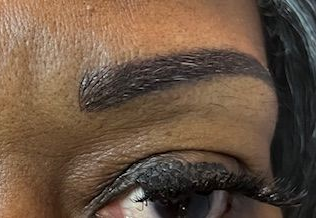 Close-up of two light blue eyes with eyeliner, mascara, and fair skin, looking forward.