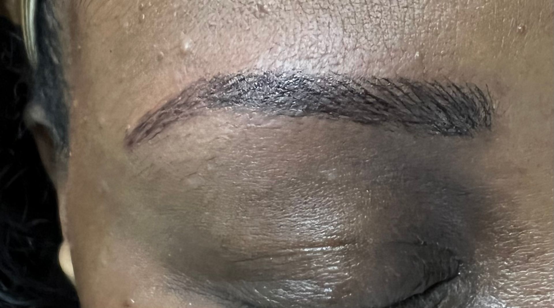 Close-up of two light blue eyes with eyeliner, mascara, and fair skin, looking forward.