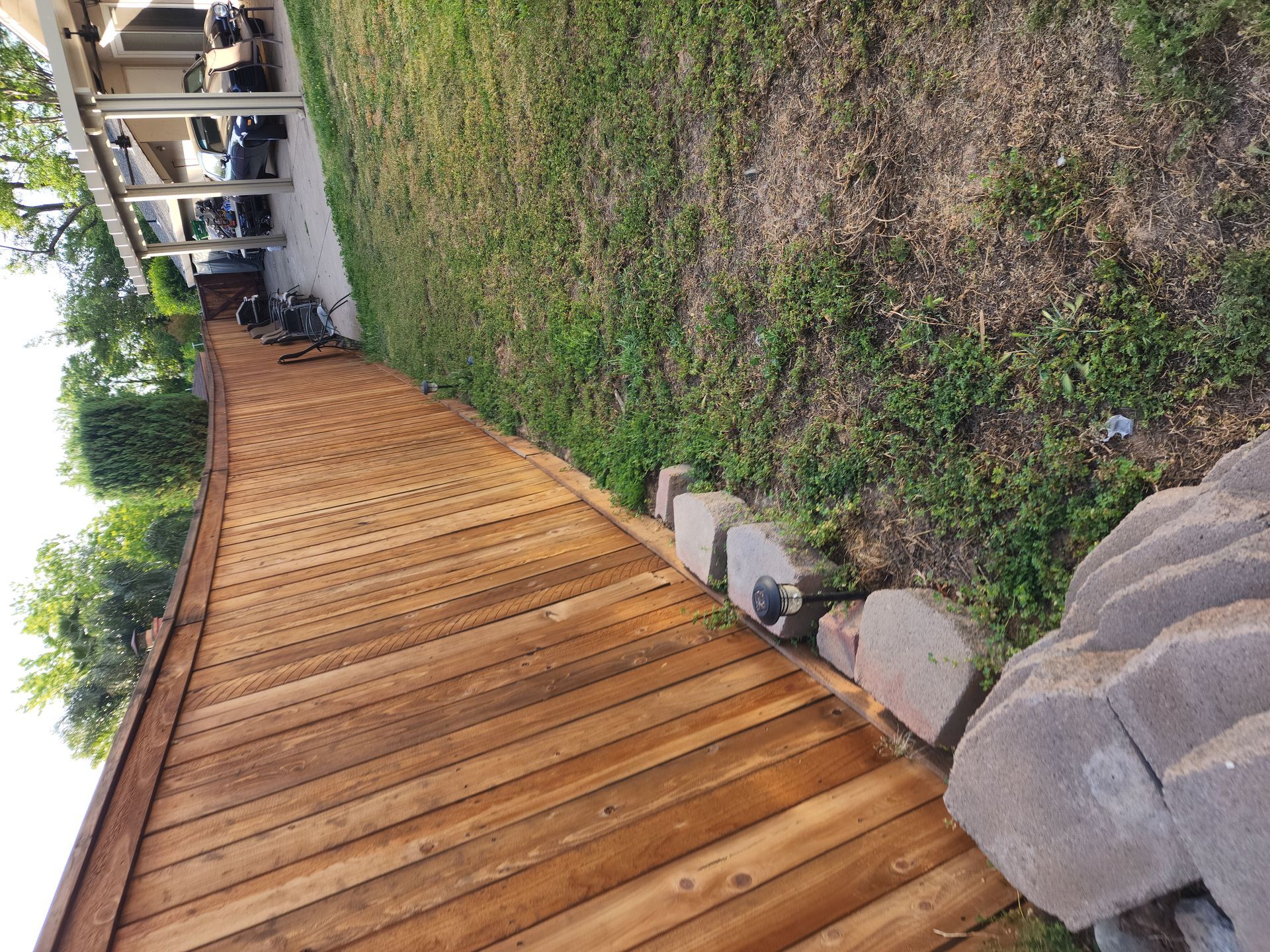 A wooden fence surrounds a lush green yard.