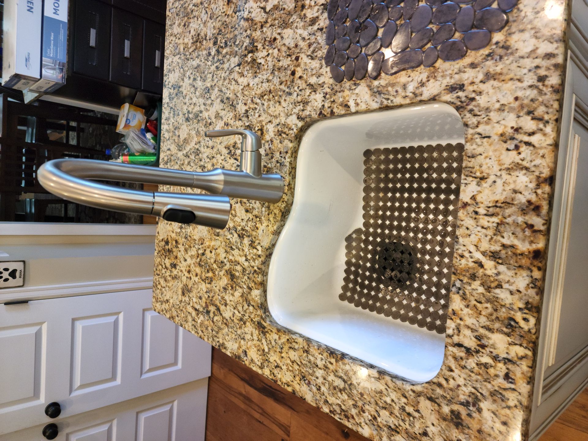 A kitchen sink sitting on top of a granite counter top