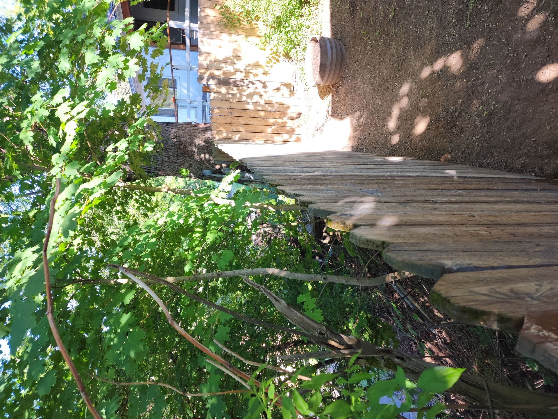 A wooden fence is surrounded by trees in front of a house