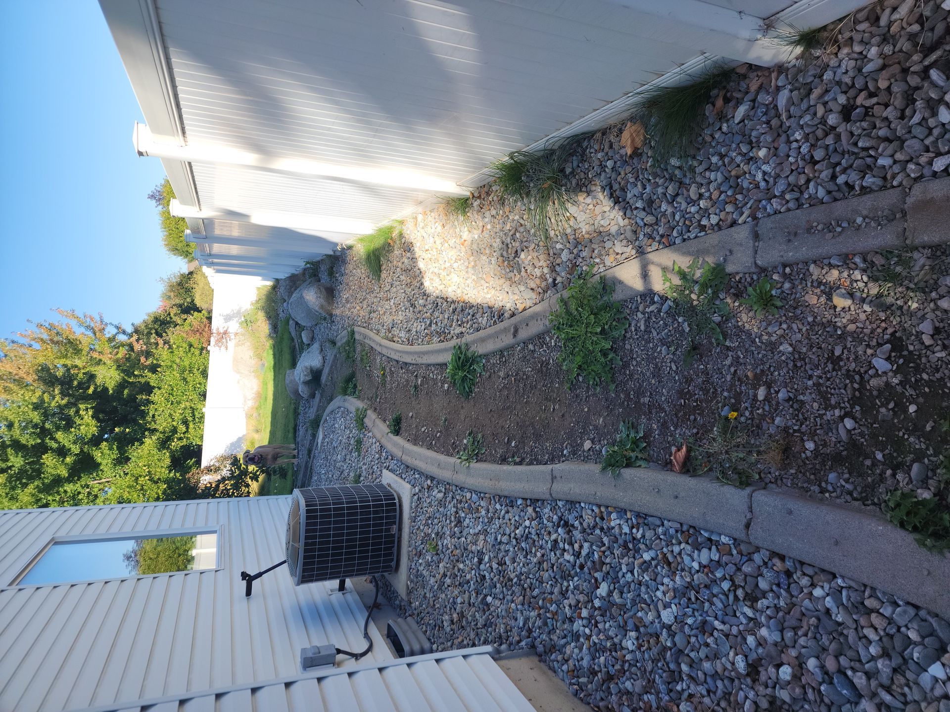 A stone walkway leading to a house with a white fence.