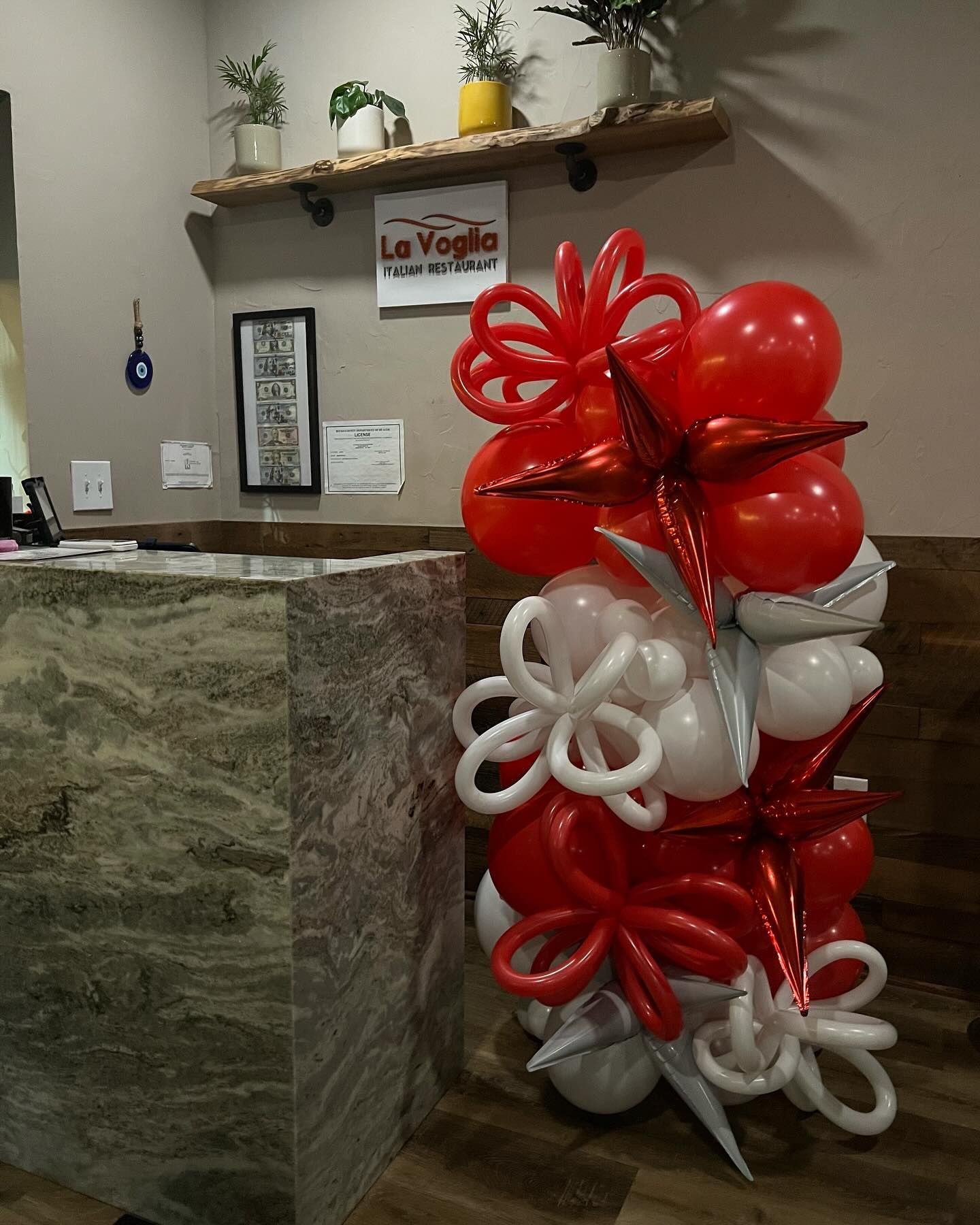 A bunch of red and white balloons in front of a sign that says le voglia