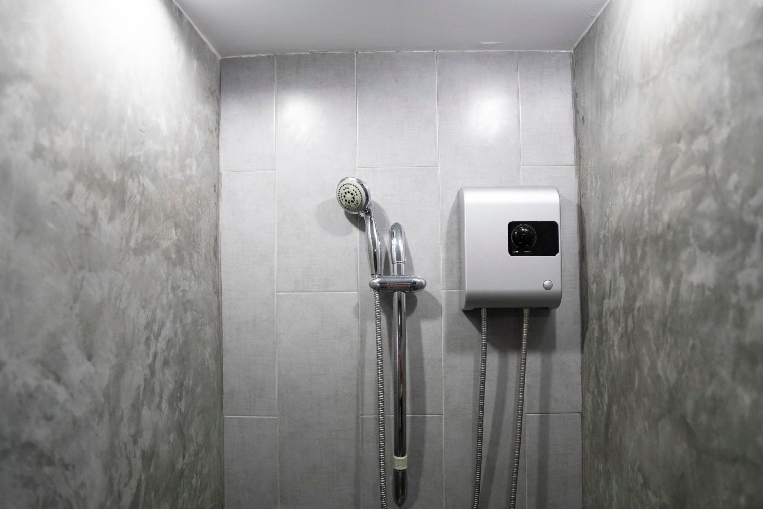 A bathroom with a shower head and a water heater.