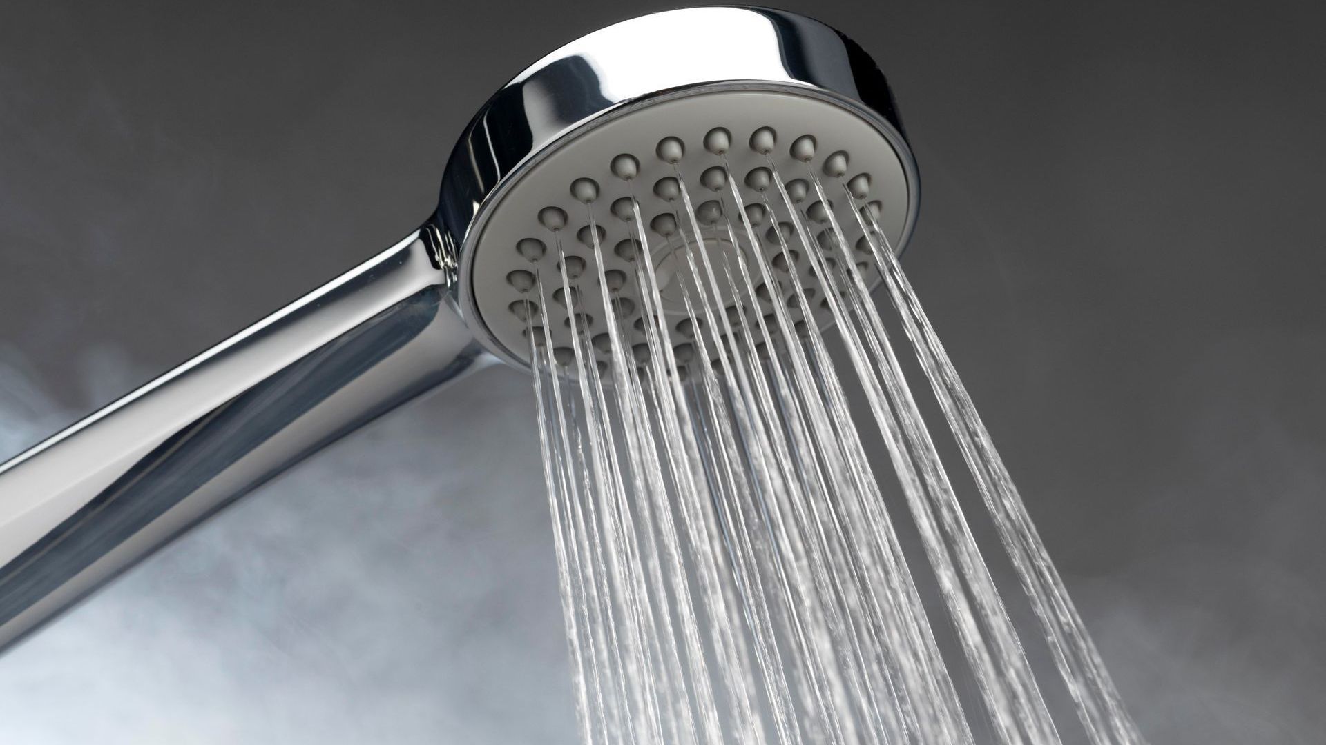 A close up of a shower head with water coming out of it