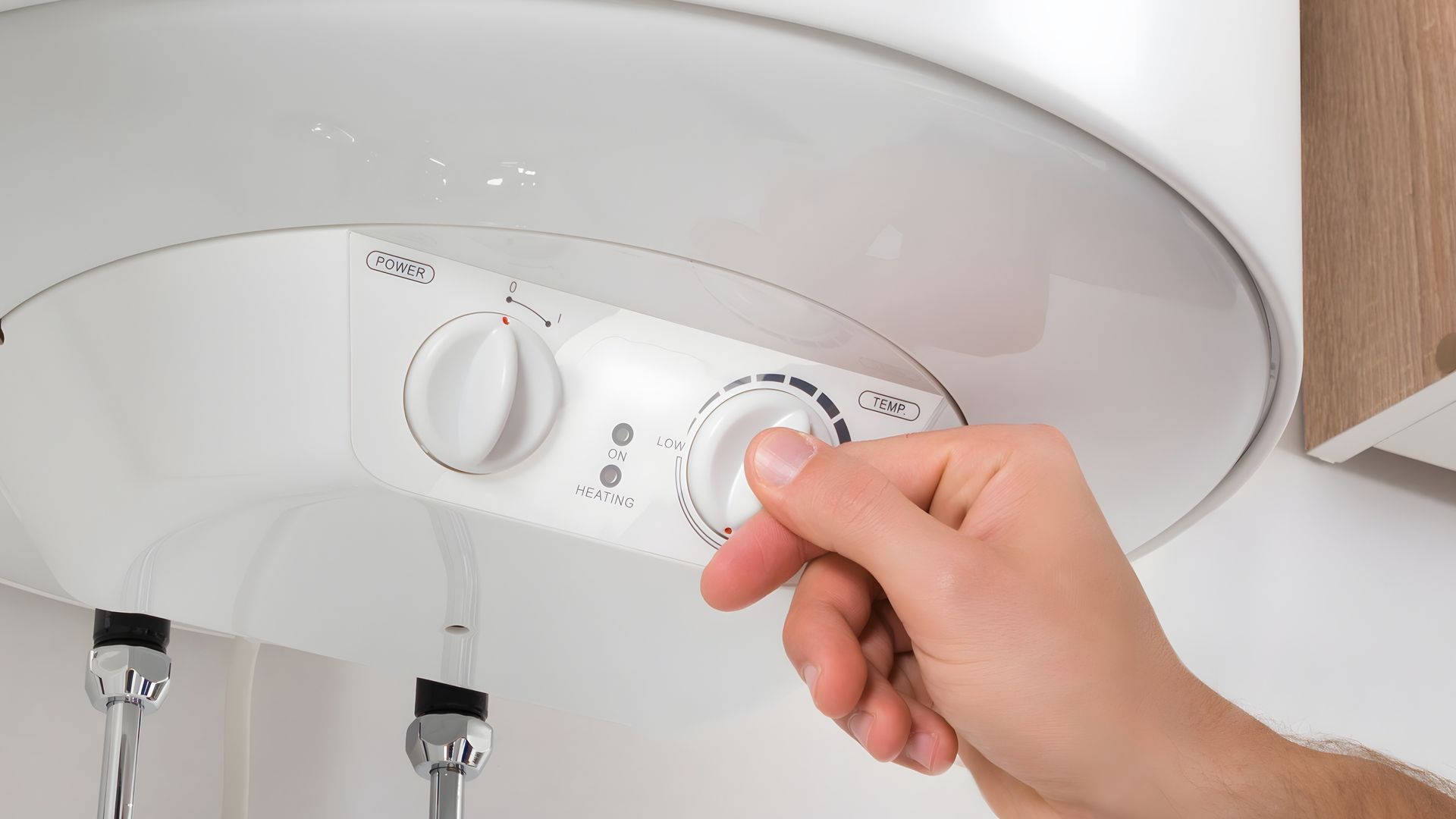 A person is adjusting the temperature of a water heater.