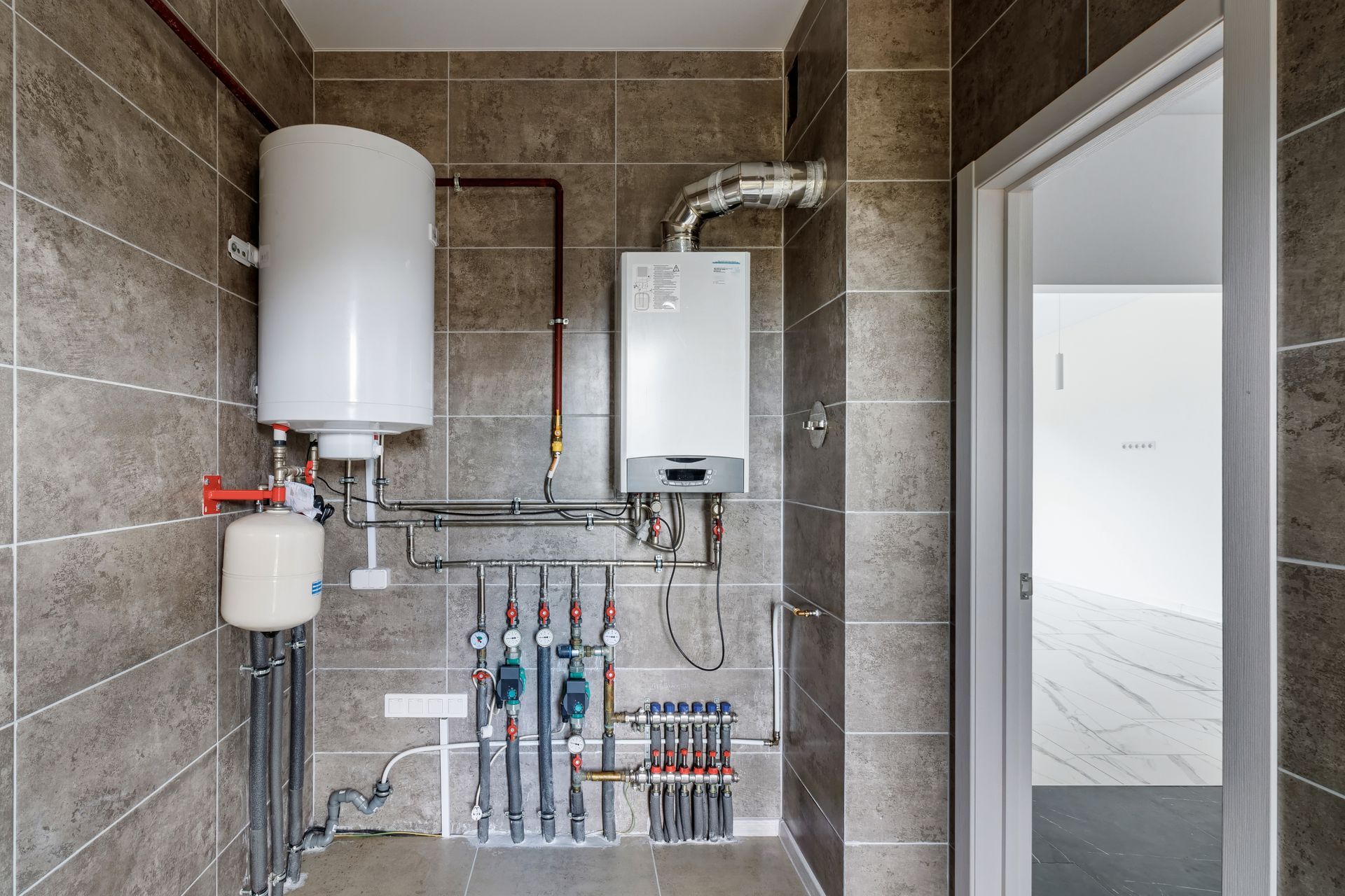 A bathroom with a boiler and a water heater.