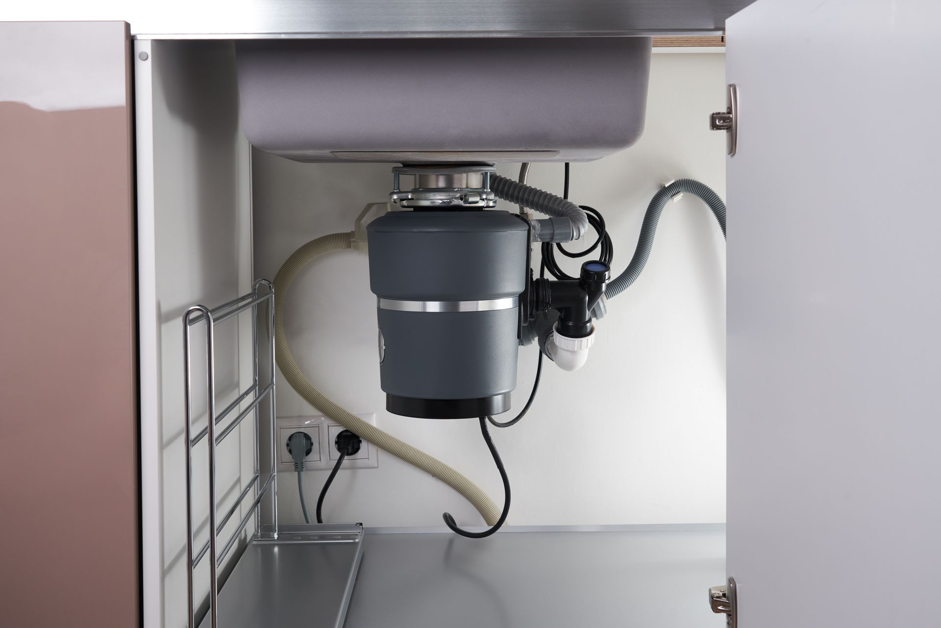 A kitchen sink with a garbage disposal underneath it.