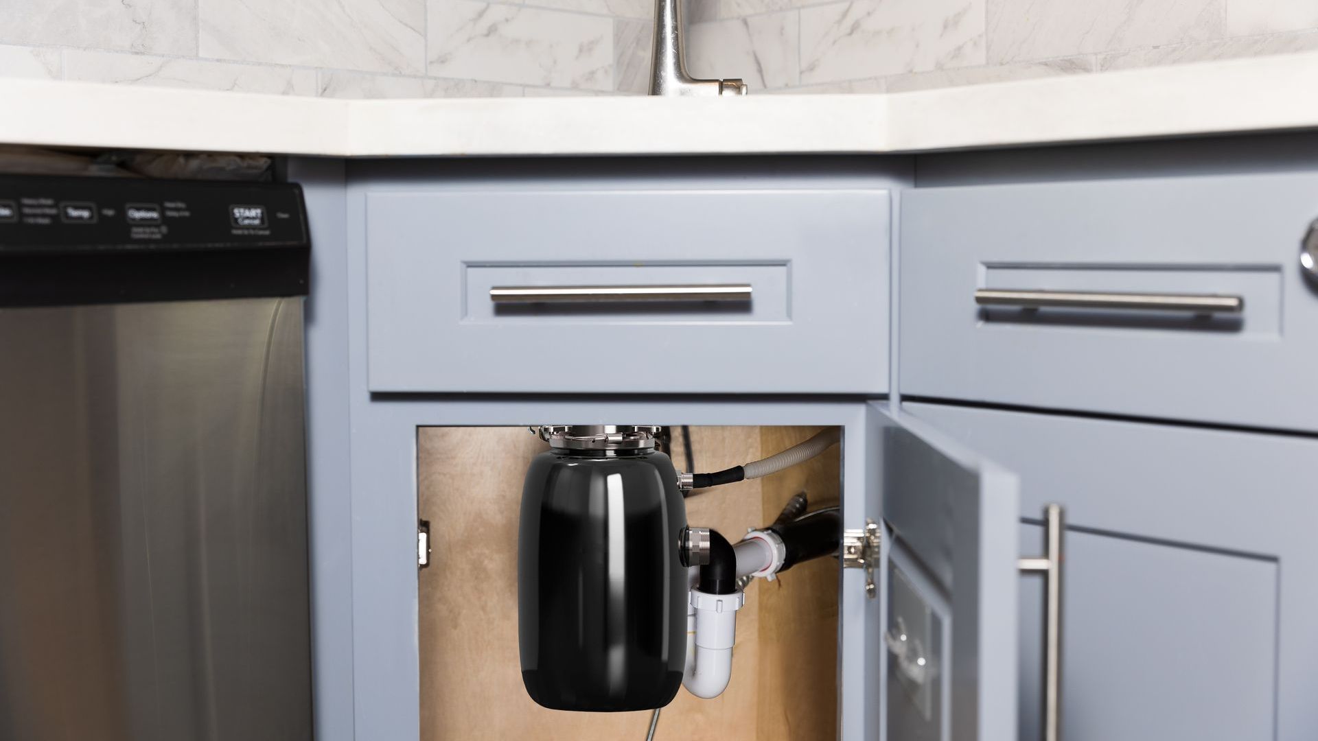A kitchen sink with a garbage disposal underneath it.