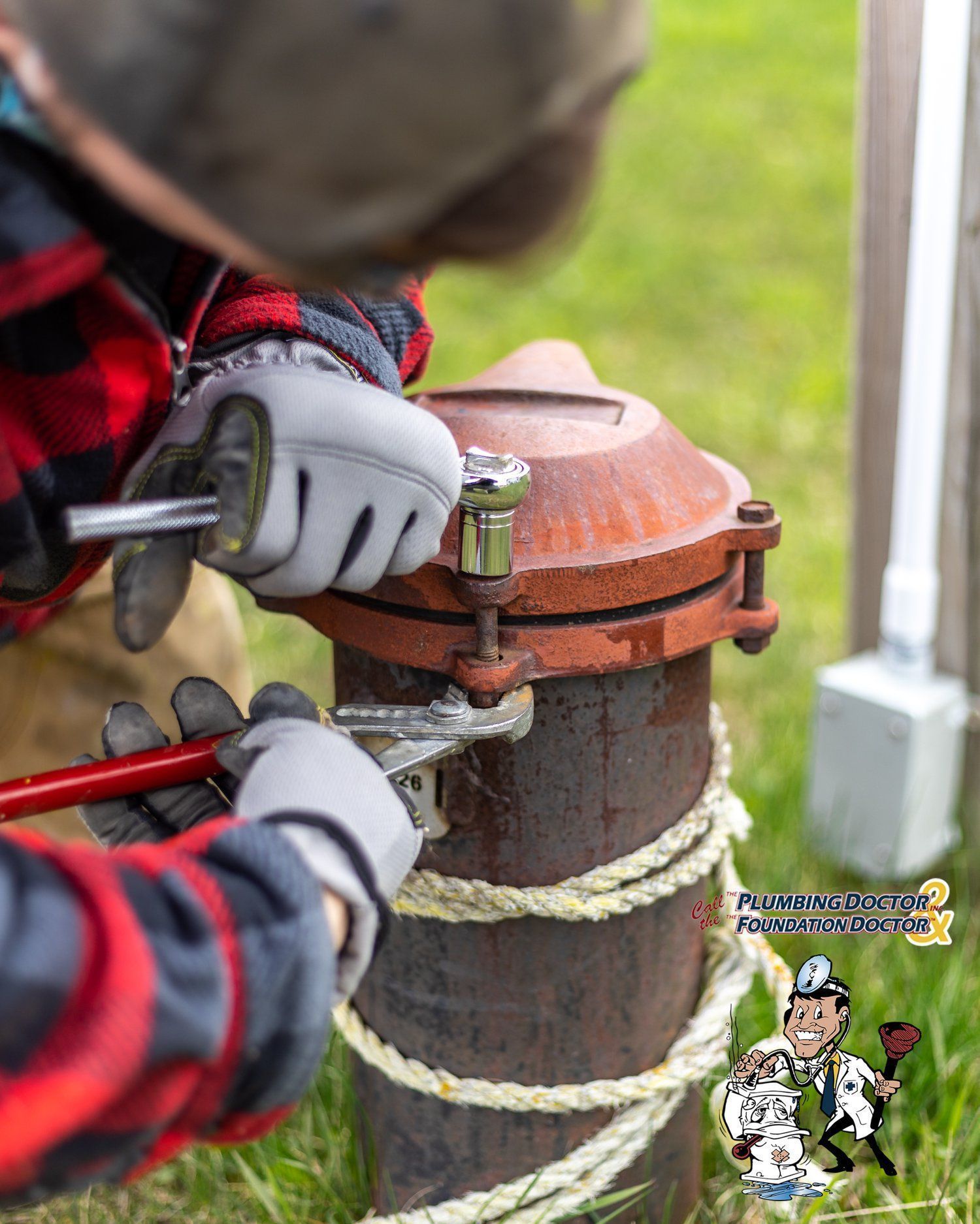 A man in a plaid shirt is working on a pipe