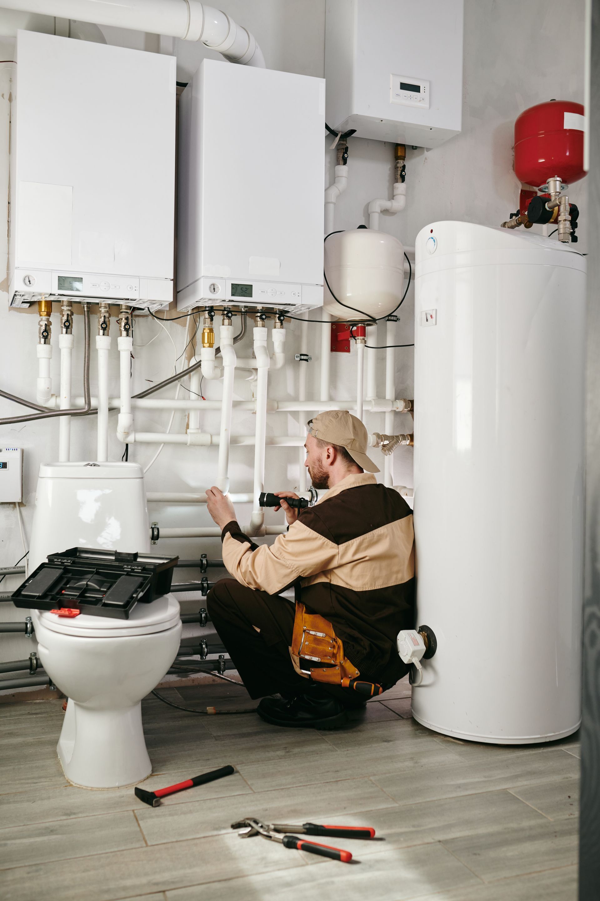 A plumber is working on a toilet in a bathroom.