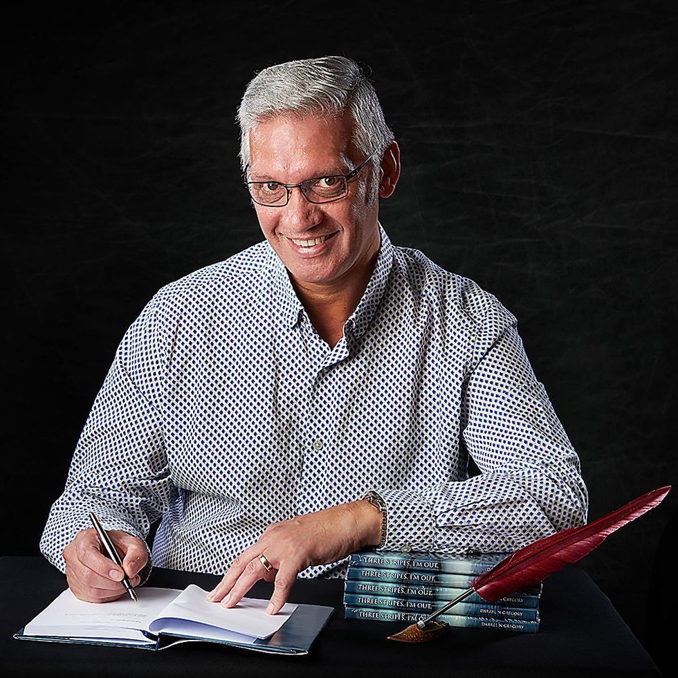 A man is sitting at a table writing in a notebook
