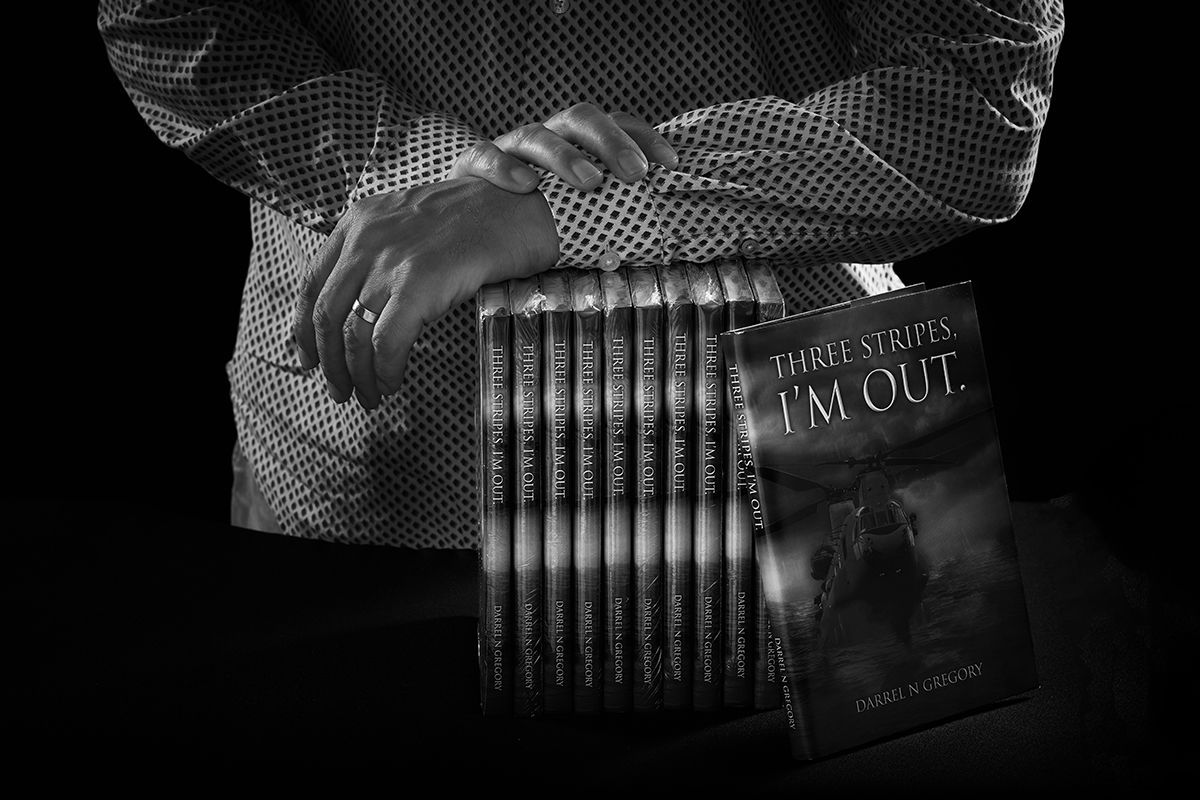 A black and white photo of a person holding a stack of books.