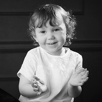 smiling girl clapping hands in black and white Oakley Studios celebration photoshoot in Luton Bedfordshire