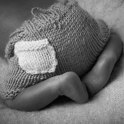 newborn baby bottom, dressed in knitted shorts, Oakley Studios celebration photoshoot in Luton Bedfordshire