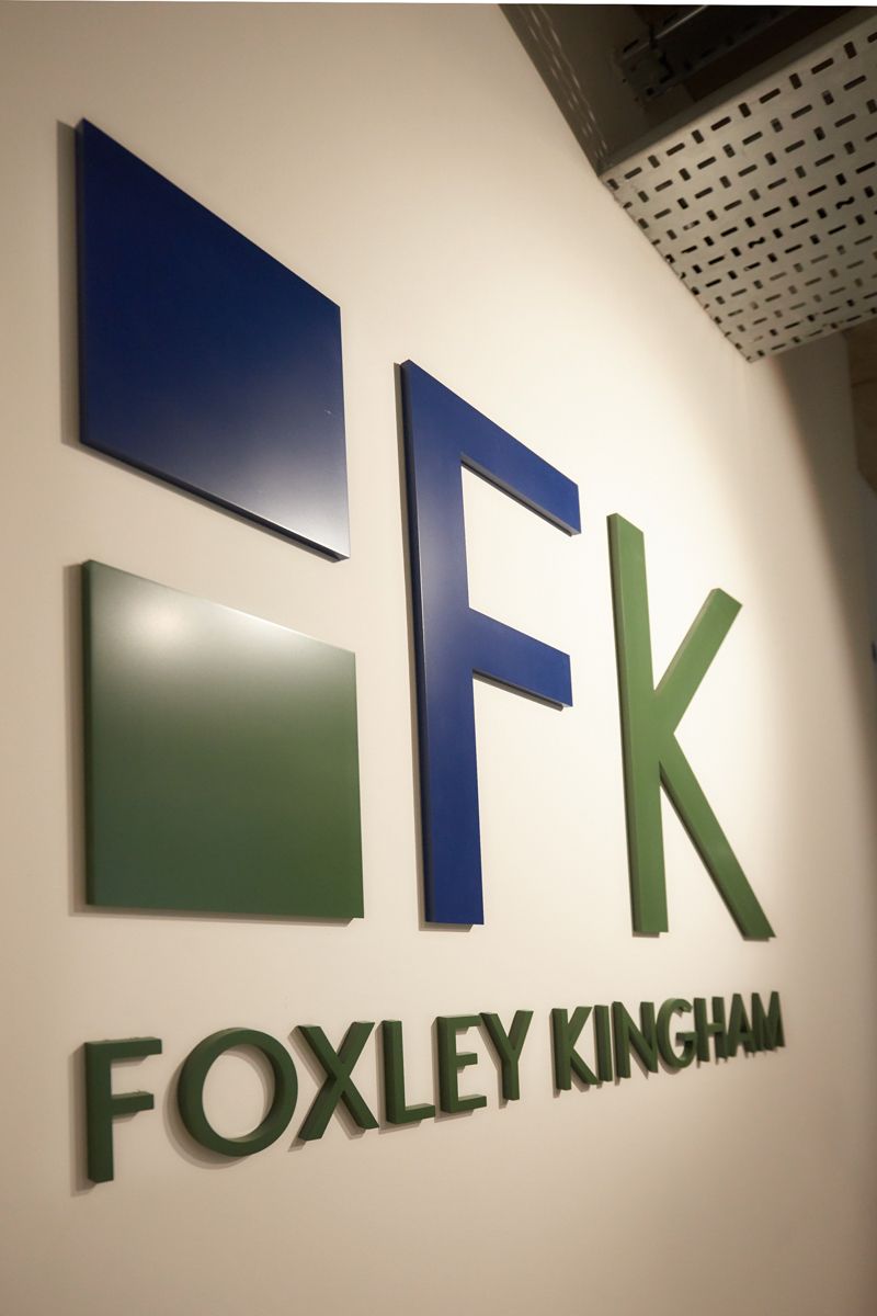 A foxley kingham logo on a white wall