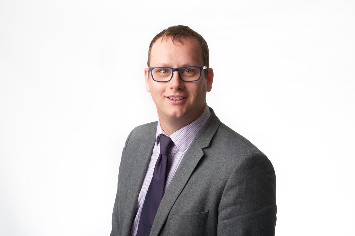 A man in a suit and tie is smiling for the camera.