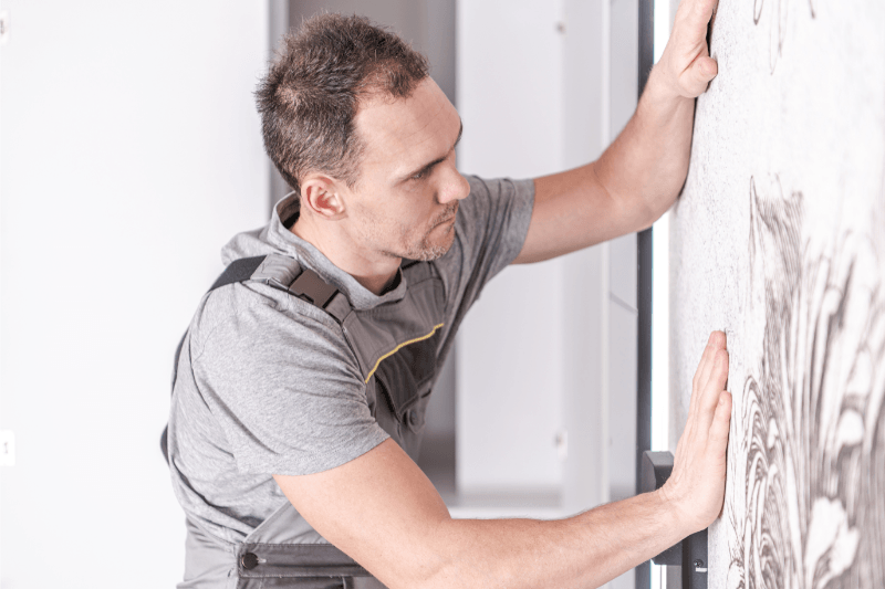 A man installing wallpaper