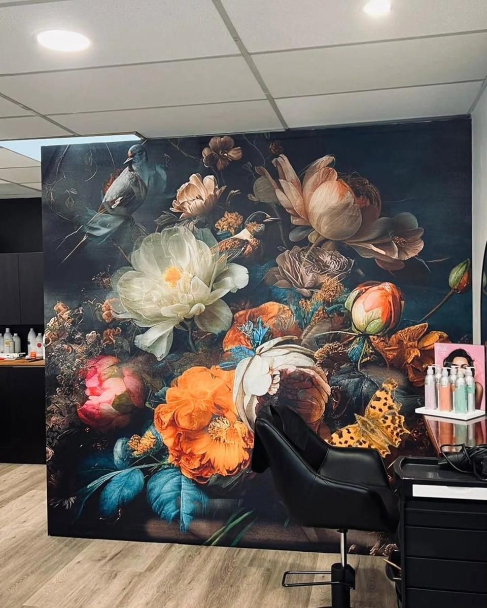 Large floral wall mural featuring oversized blooming flowers in rich blue, orange, and cream tones