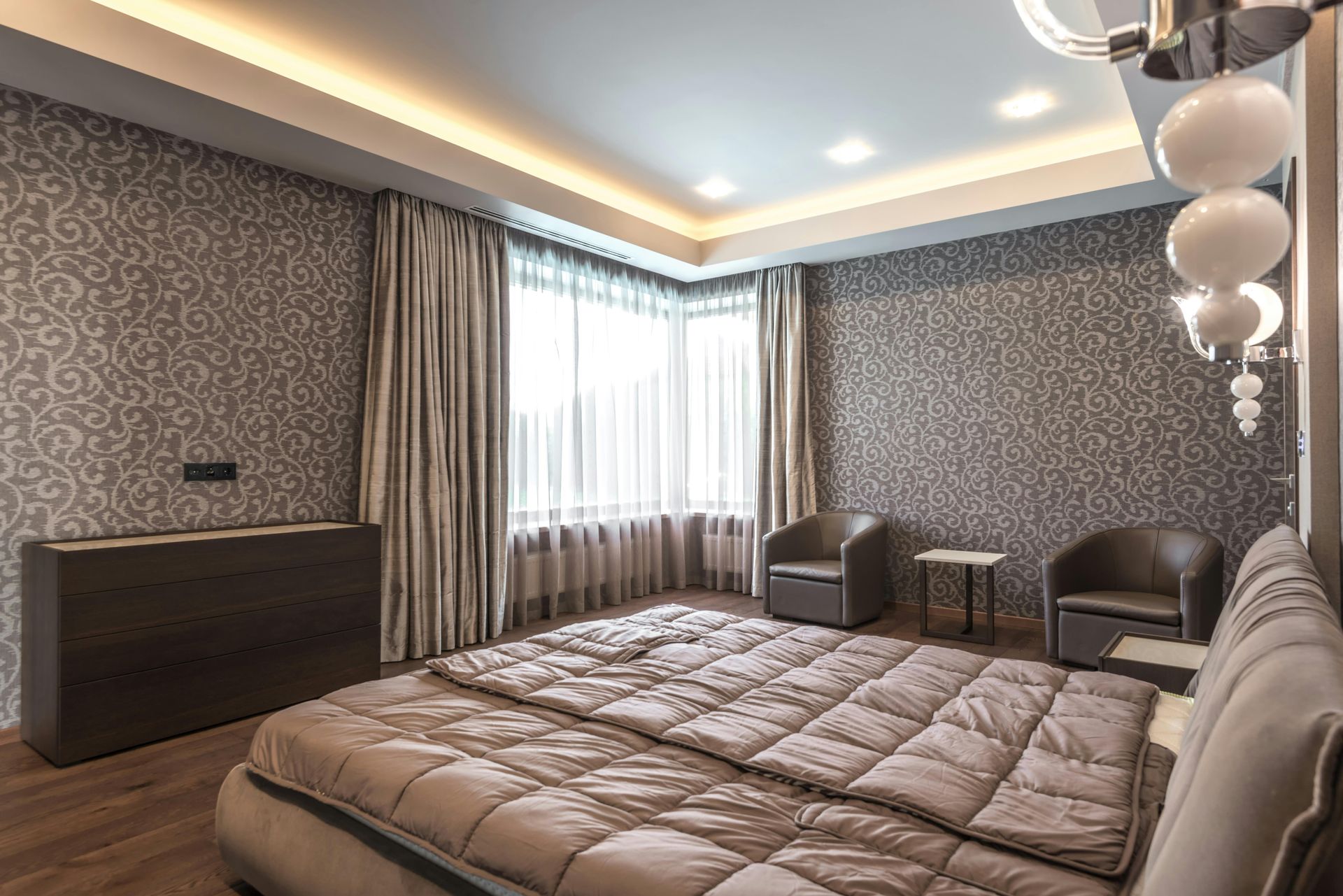 A modern bedroom featuring elegant patterned wallpaper