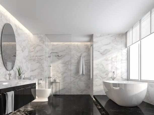 Luxurious bathroom with marble walls, black floor, oval mirror, soaking tub, and large window.