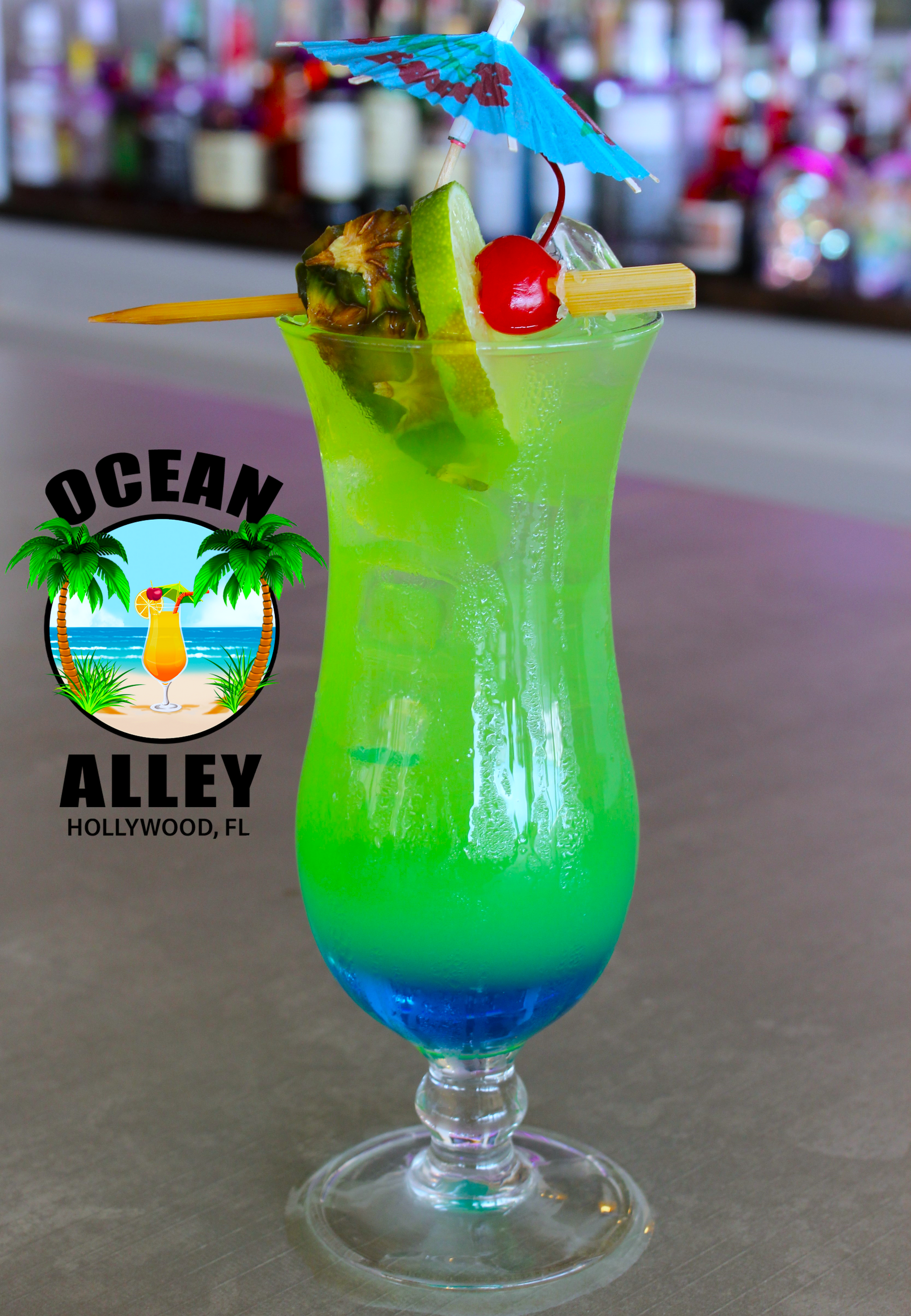 A glass of ocean alley cocktail with a cherry on top