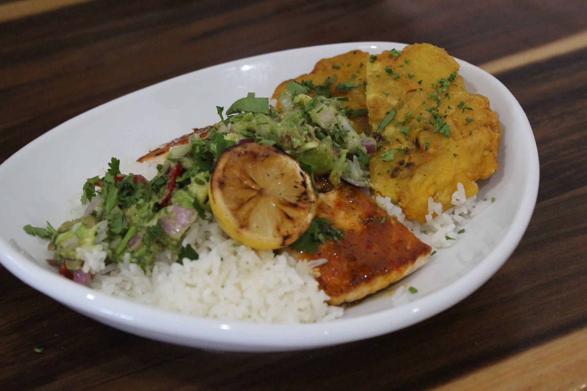 A plate of food with rice and meat on a wooden table
