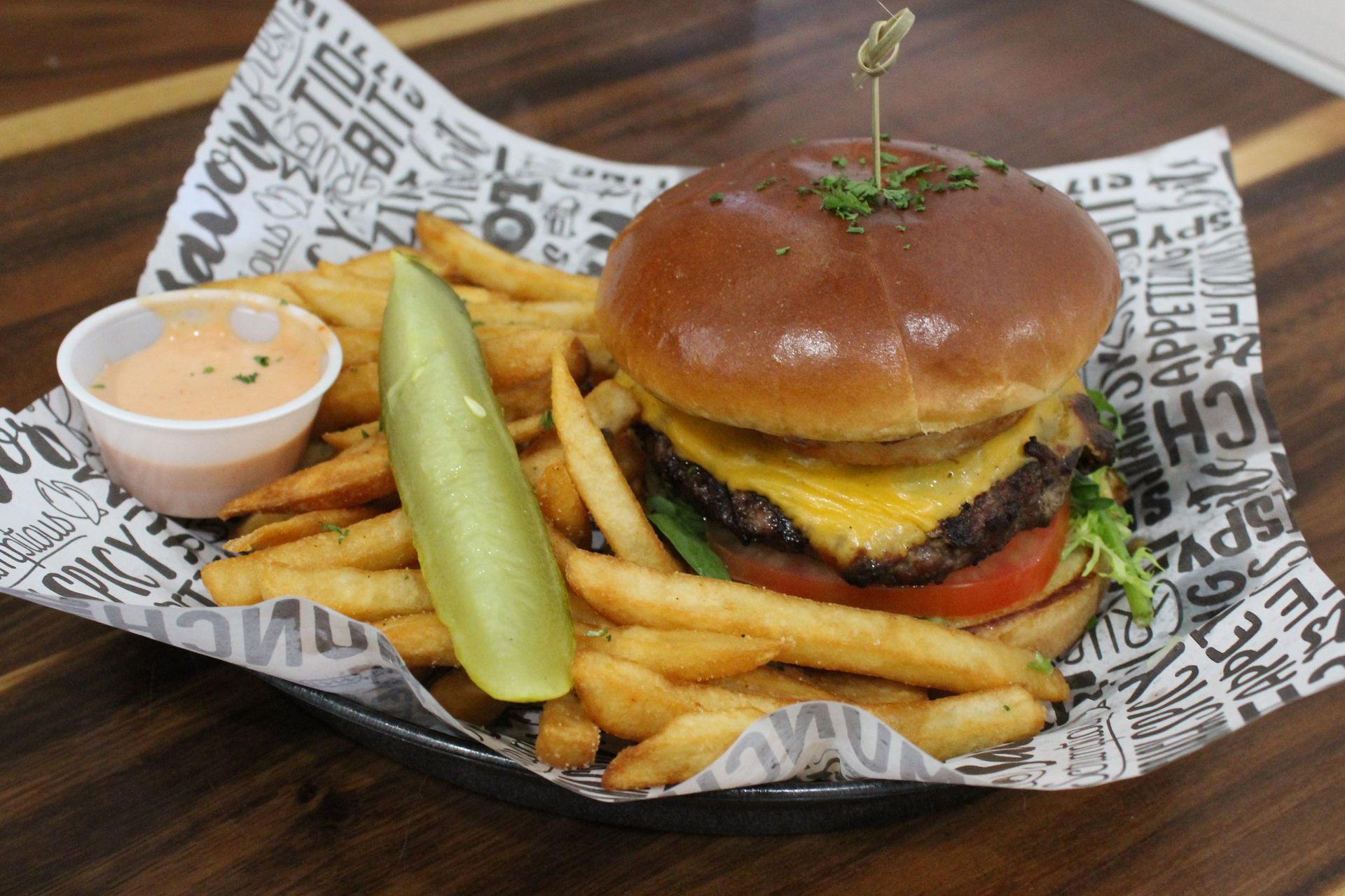 A hamburger and french fries in a basket on a table.